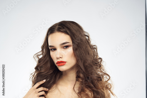 woman with bare shoulders wavy hairstyle glamor makeup light background