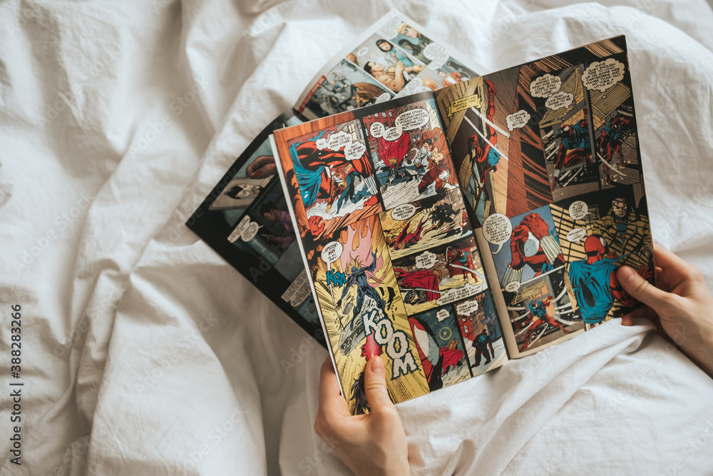 Obraz premium Woman reading comic book in the bed at home. Rostov-on-Don, Russia. 14 April 2020
