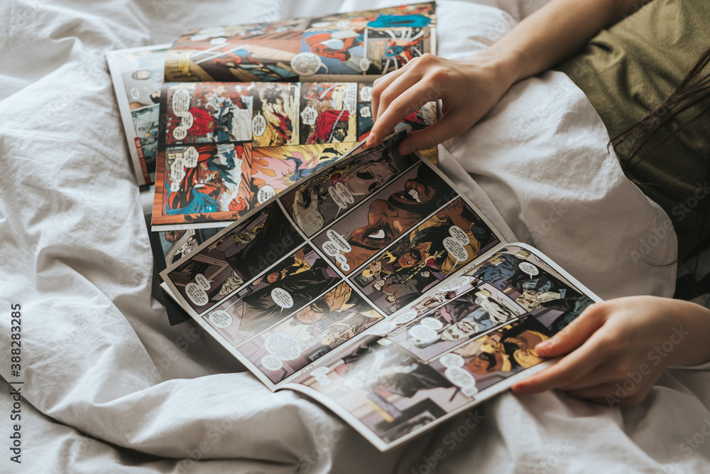 Obraz premium Woman reading comic book in the bed at home. Rostov-on-Don, Russia. 14 April 2020