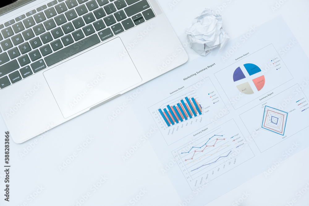 charts and graph on paper sheets and laptop on white background in business concept