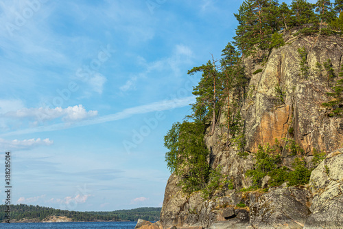 beautiful landscape with green, natural plants, trees on a mountain, rocks on an island near a reservoir, lake in the summer of Karelia, Russia
