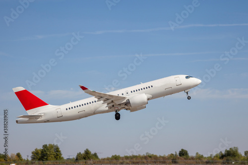 White plane flies in the sky. Takeoff and landing. Arrival and departure. Place for your text. Passenger plane isolated on blue background. Passenger airplane. Travel by air transport. Flying.