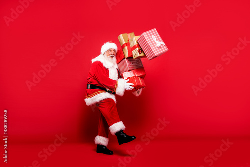 Santa Claus with a lot of gifts on a red background.