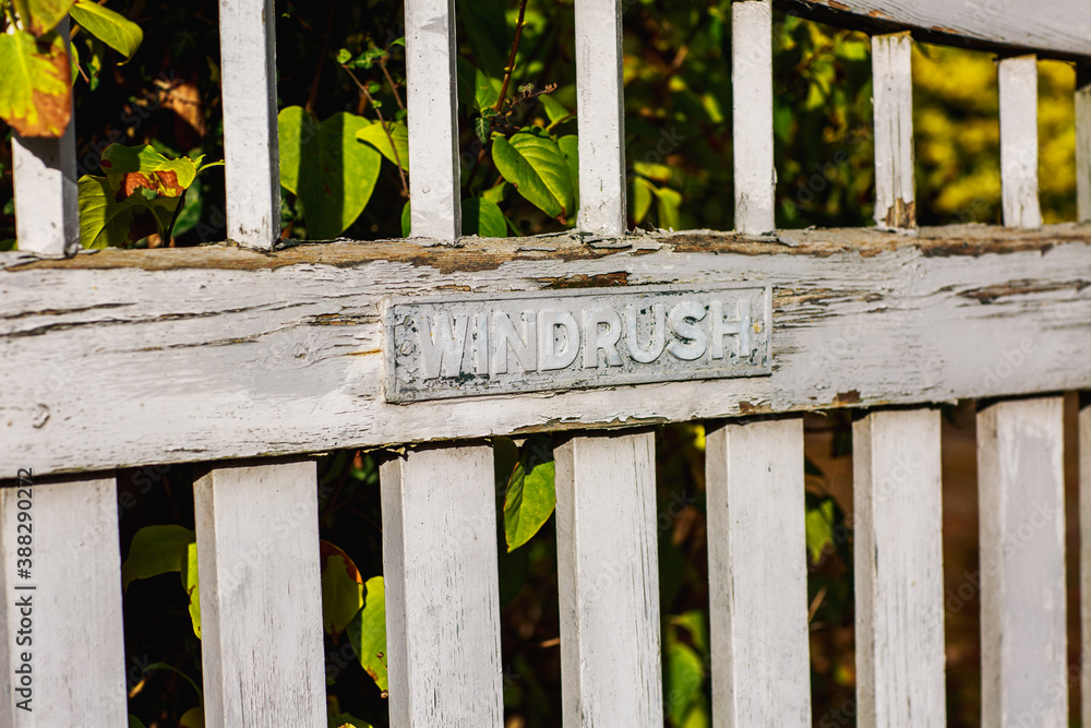 old painted wooden fence gate where the paint is starting to flake and the wood rot with the nameplate old painted wooden fence gate where the paint is starting to flake and the wood rot with the nameplate