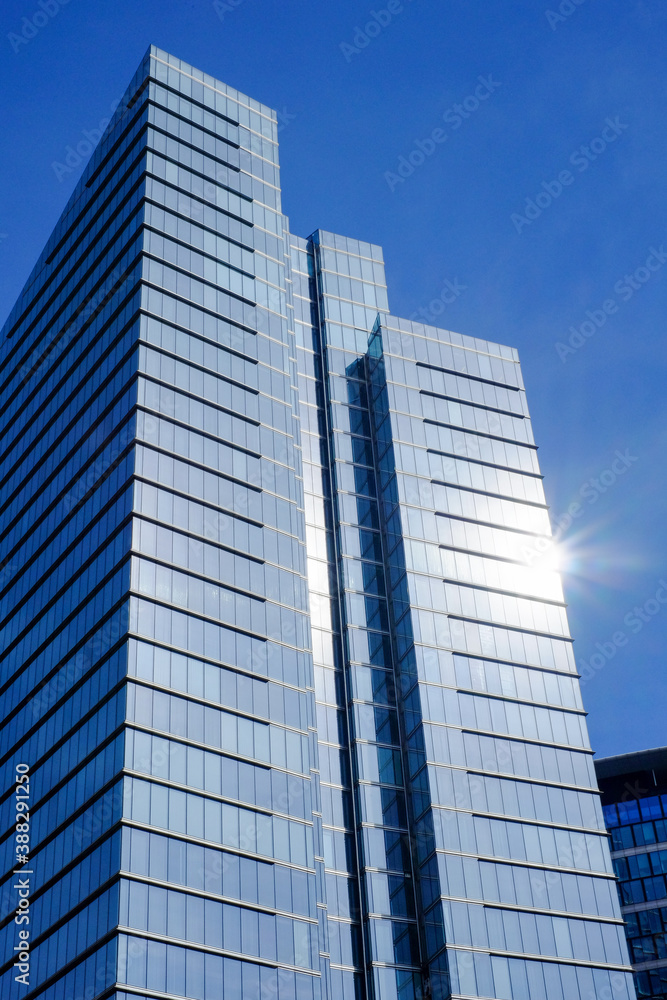 Low angle view of modern business buildings in city against blue clear sky Low angle view of modern business buildings in city against blue clear sky