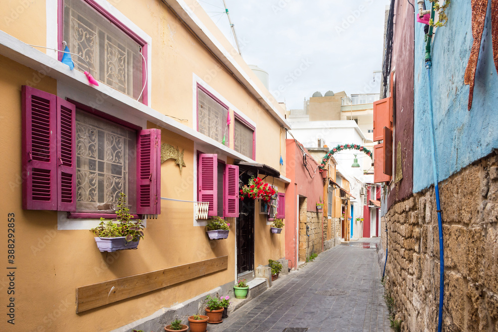 Fototapeta premium Small alleyway with colorful houses, Christian quarter in the Mediterranean coastal town Tyre, Lebanon