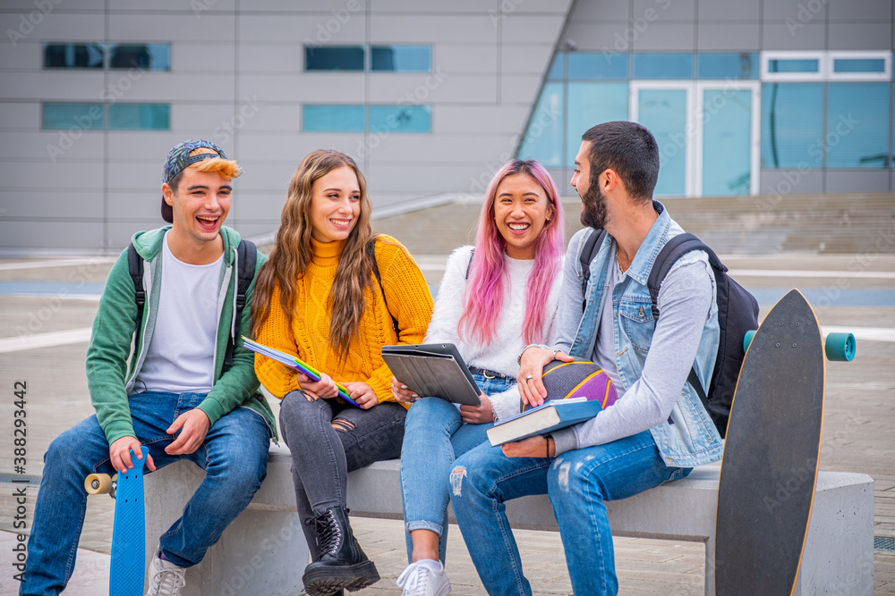 © damianobuffo - Multiethnic students joking and talking sitting on the bench together outdoors in a university - Group of happy young teenagers studying with books and tablets © damianobuffo - Multiethnic students joking and talking sitting on the bench together outdoors in a university - Group of happy young teenagers studying with books and tablets
