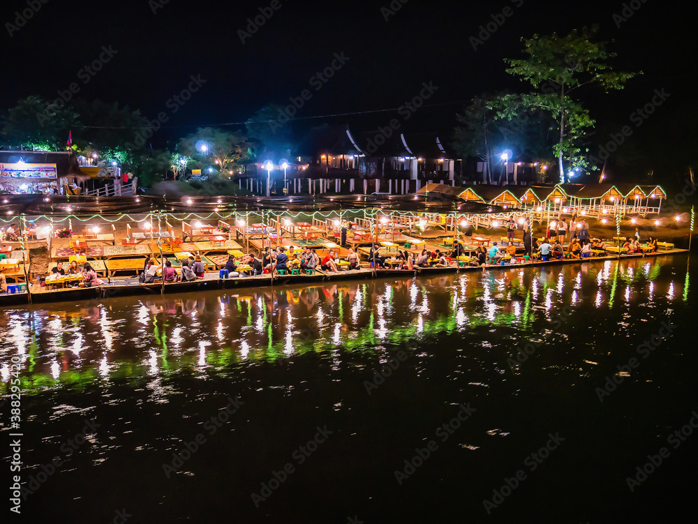 Beautiful view of nam song river with Tourist on riverside restaurant and the mountain in the night at Vangvieng city Lao.Vangvieng City The famous holiday destination town in Lao.