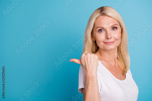 Positive old woman point thumb finger copyspace wear good look outfit isolated blue color background