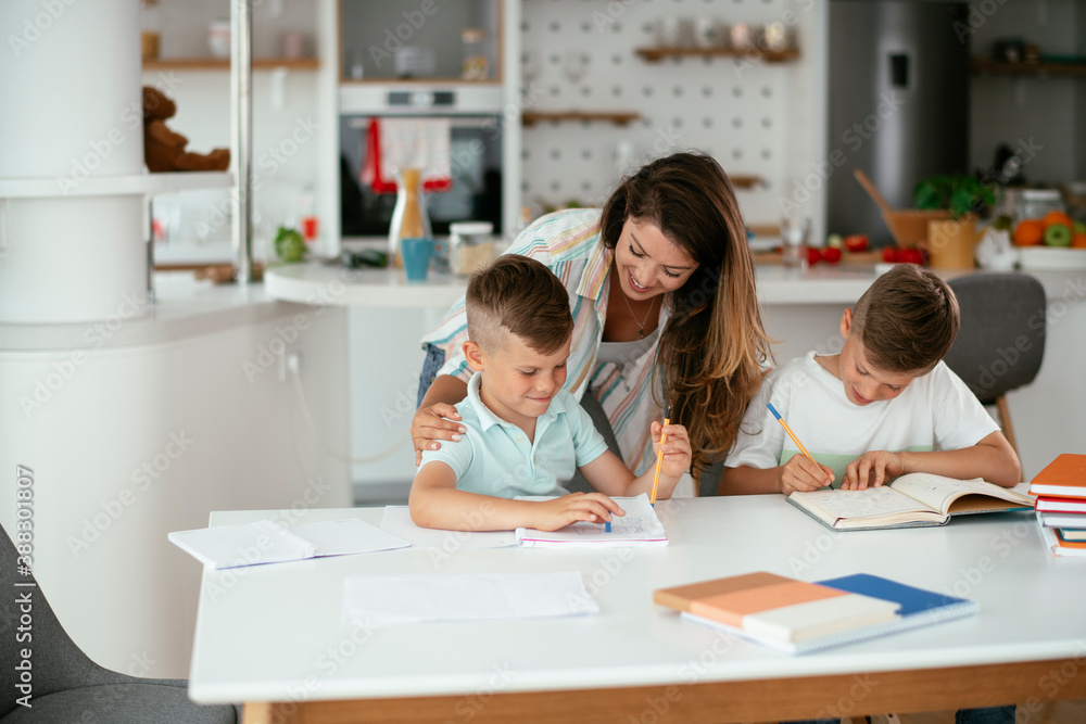Mother helping her son with homework at home. Little boy learning at home.. Mother helping her son with homework at home. Little boy learning at home..