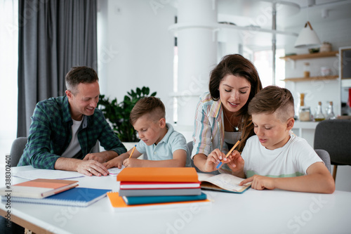Parents helping the kids with their homework. Litlle boys learning at home.