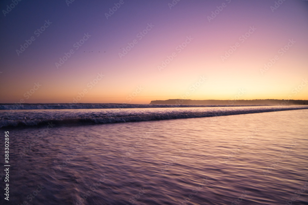 waves of the pacific ocean near the shore at sunset