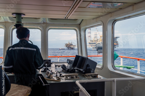 Offshore Terengganu oil field,, Malaysia - May 20, 2017: A supply boat captain maneuvering forward bridge while heading to a platform for transferring material and equipment at Terengganu oil field.