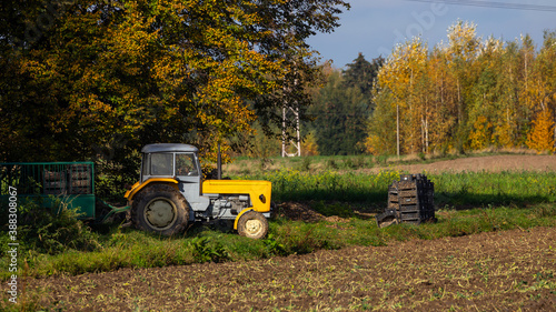 Classic yellow tractor during autumn field work