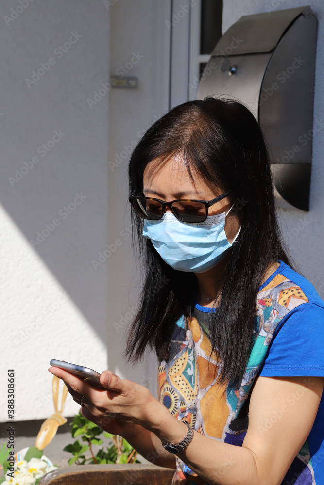 woman wearing mask with smart phone