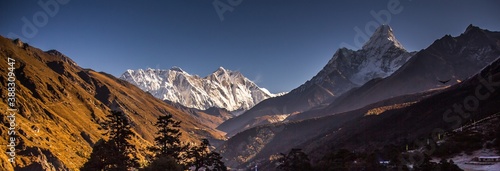 Panoramic view of mountain valley and snowcapped peaks of the Himalayas. Ama Dablam (6,812m) is on the right. Nepal. Bright autumn sky.