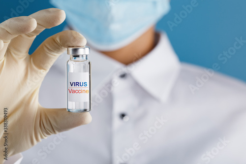 Virus Vaccine on an ampoule in the hands of a scientist doctor in rubber gloves with a vaccine close-up.
