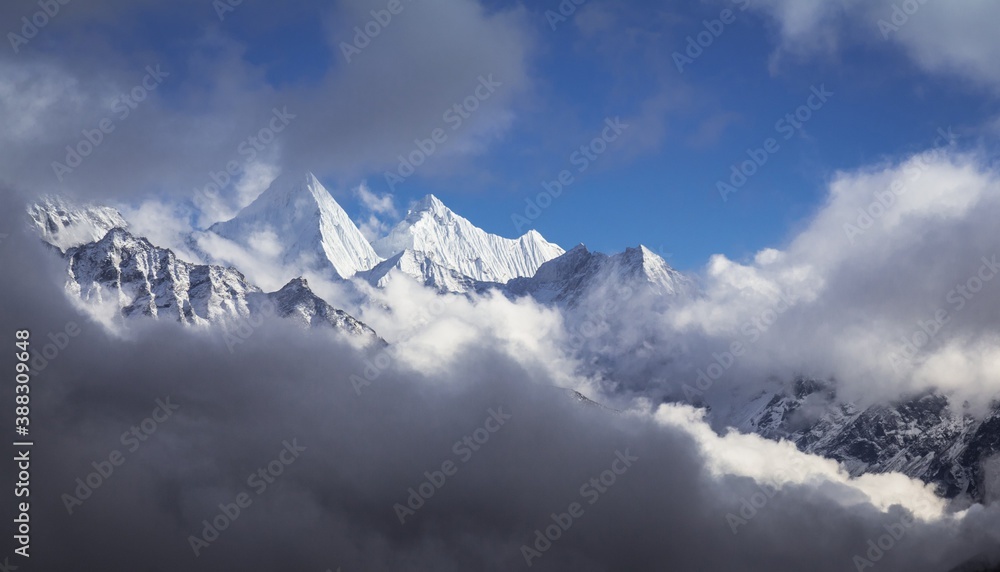 Snow white peaks of Nepalese Himalaya mountains are seen through light clouds. Somewhere near Tukla village on the way to Everest base camp. .