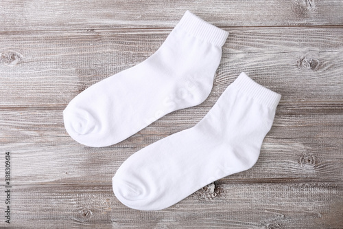 Twa, a pair of white cotton classic socks on wooden background photo