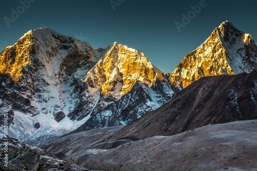 Taboche (6,495m) and Cholatse (6,440m) mountains in early morning which peaks lightened with sun beams. The Himalaya mountains. Nepal.