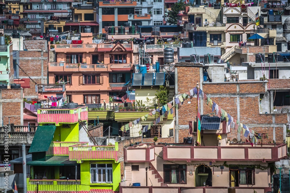 Closeup of colorful houses with flags, flowers on the balconies, solar panels and clothes in a sunny day in Kathmandu, Nepal.