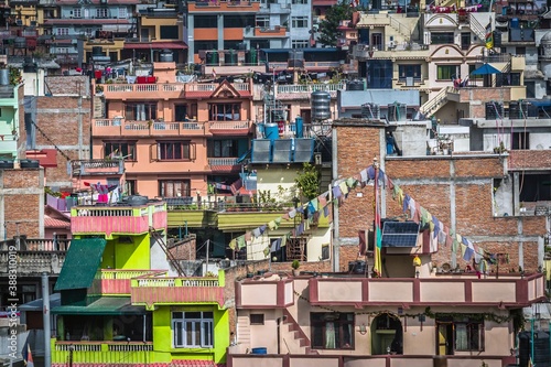 Closeup of colorful houses with flags, flowers on the balconies, solar panels and clothes in a sunny day in Kathmandu, Nepal.