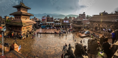KATHMANDU, NEPAL - OCTOBER 29, 2017. Panoramic view on Durbar Square in rainy weather in Bhaktapur, Nepal. View from top on asian city center with old buildings  and many people walking around.