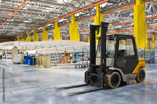 New self propelled lifting platform inside a modern assembly shop full of equipment.