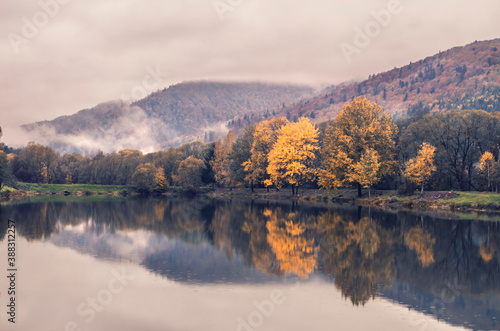 Fototapeta Naklejka Na Ścianę i Meble -  Autumn park with pond. Lake reflections of fall foliage.
