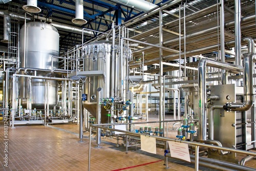 Production of beer: steel reservoirs and pipes in a brewery.