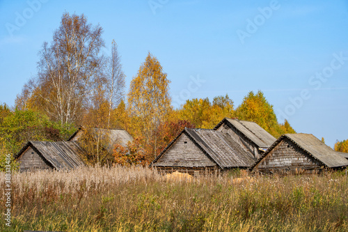 Foto Old, ramshackle village houses among dry, autumn grass