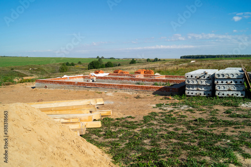 Construction of the foundation for building in field on background blue sky