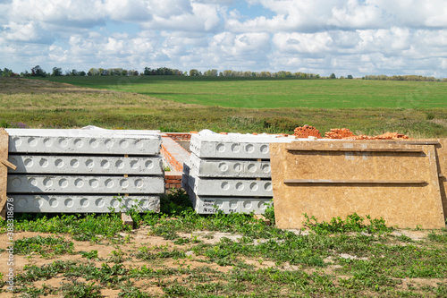 Construction of the foundation for building in field on background blue sky