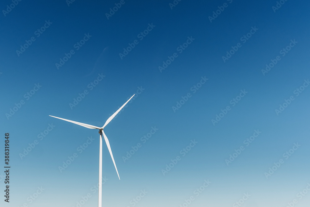 Eolienne dans un champ avec un grand ciel bleu Eolienne dans un champ avec un grand ciel bleu