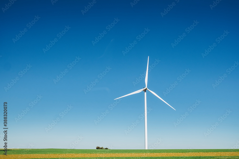 Eolienne dans un champ avec un grand ciel bleu Eolienne dans un champ avec un grand ciel bleu