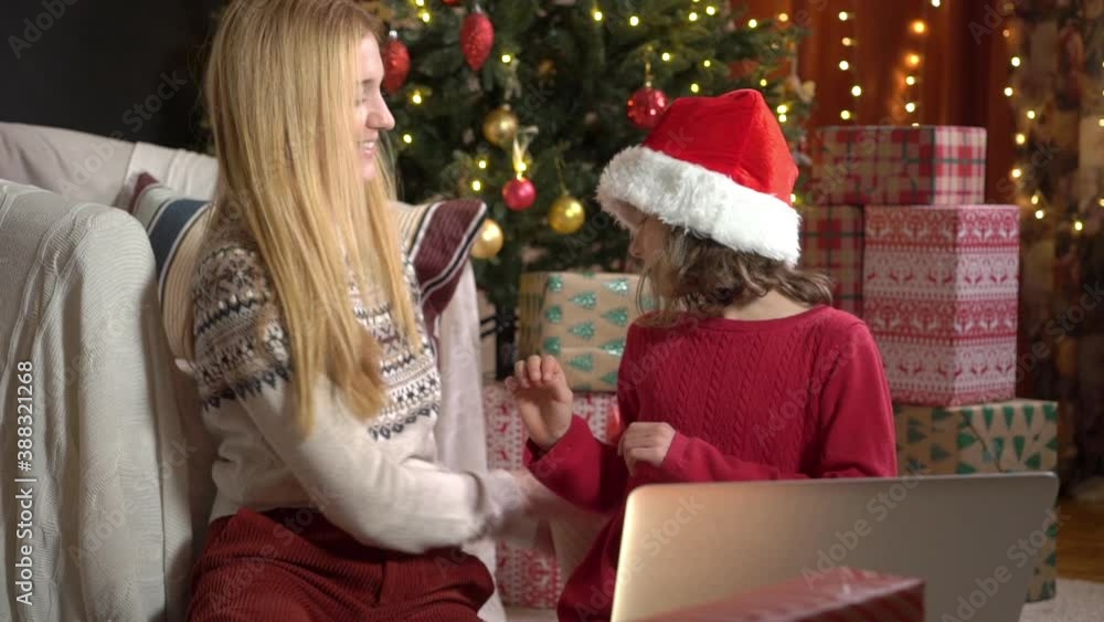 A happy mom with a child is celebrating Christmas with their friends using a video call. Family greeting your relatives on Christmas eve online. Social distancing, self isolation during quarantine A happy mom with a child is celebrating Christmas with their friends using a video call. Family greeting your relatives on Christmas eve online. Social distancing, self isolation during quarantine