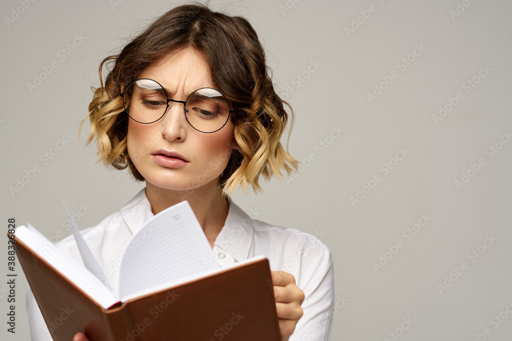 Business woman with notepad and glasses on a light background hairstyle success emotions Business woman with notepad and glasses on a light background hairstyle success emotions