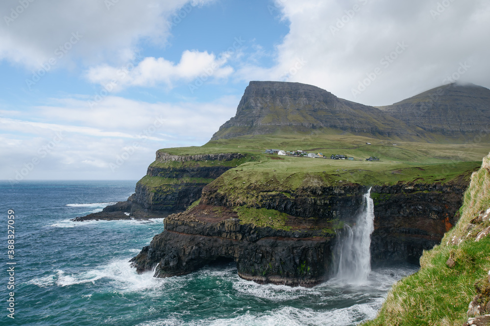 Gásadalur located on the west side of Vágar, Faroe Islands. The village sits high and with a sheer drop where the waterfall Múlafossur plunges into the ocean.
