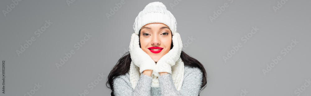 joyful and brunette woman in winter outfit looking at camera isolated on grey, banner joyful and brunette woman in winter outfit looking at camera isolated on grey, banner