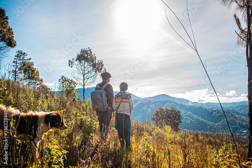 dos jóvenes parados en la en la montaña  con cielo brillante   photo