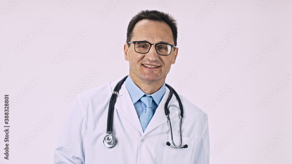 Handsome doctor in medical coat writes prescription on clipboard looks at camera with smile on white background. Healthcare, medicine, health, medical specialist, patient diagnosis, treatment concept Handsome doctor in medical coat writes prescription on clipboard looks at camera with smile on white background. Healthcare, medicine, health, medical specialist, patient diagnosis, treatment concept