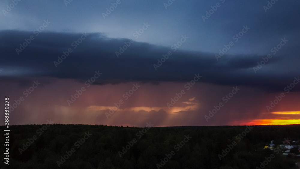 Obraz premium Thundercloud with rain at sunset. Dark blue sky