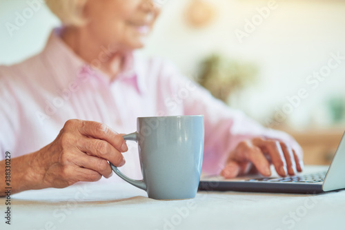 Close up of elderly lady holding cup of coffee