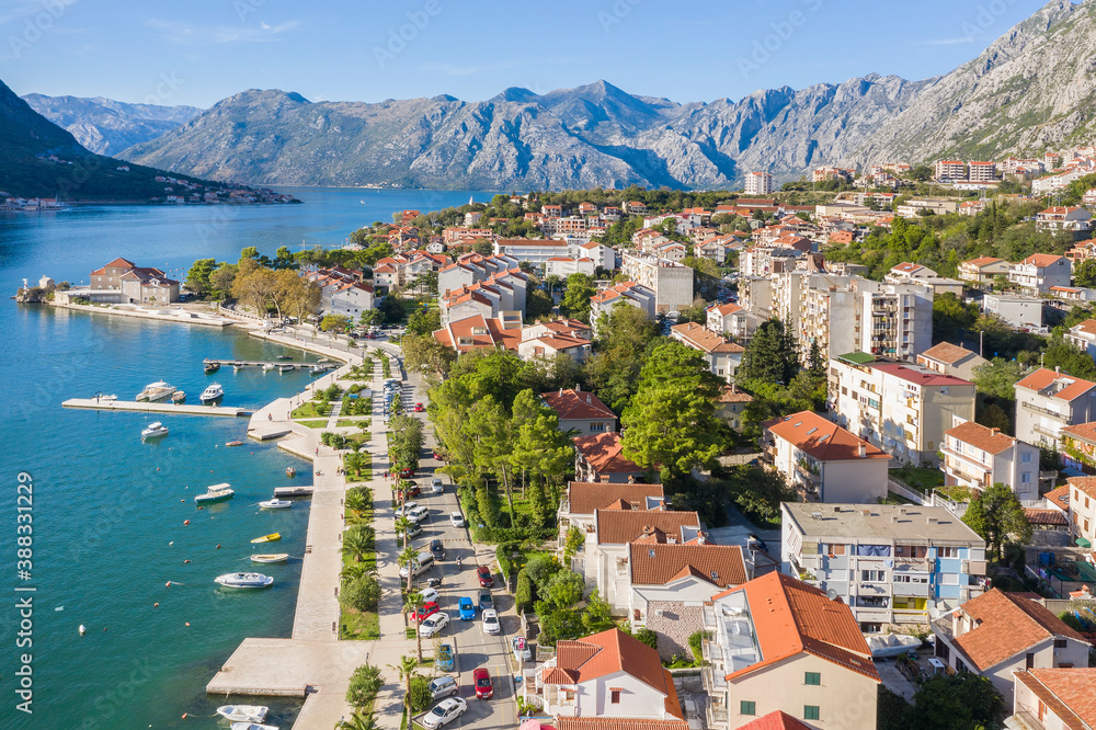 Aerial photo of the coastline of the Adriatic sea bay, small Montenegrin town. Water in the sea is turquoise, pure and clear. White boats swaying on the waves and yachts sailing on the sea