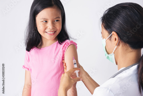 Doctor injecting vaccination in arm of asian little child girl  little asia girl receiving injection from doctor. healthy and medical concept.