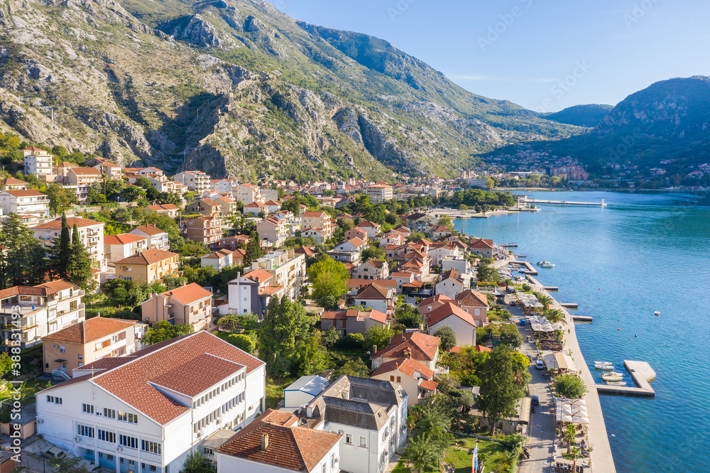 Aerial photo of the coastline of the Adriatic sea bay, small Montenegrin town. Water in the sea is turquoise, pure and clear. White boats swaying on the waves and yachts sailing on the sea