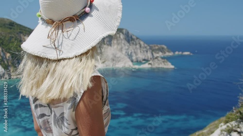 Woman traveller on top of mountain looking at beautiful sea bay celebrating scenic landscape on vacation travel adventure nature. photo