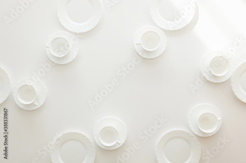 Weiße Kaffeetassen und Teller auf weißem Tisch