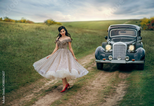 Obraz na płótnie Young beautiful happy retro woman near the old car