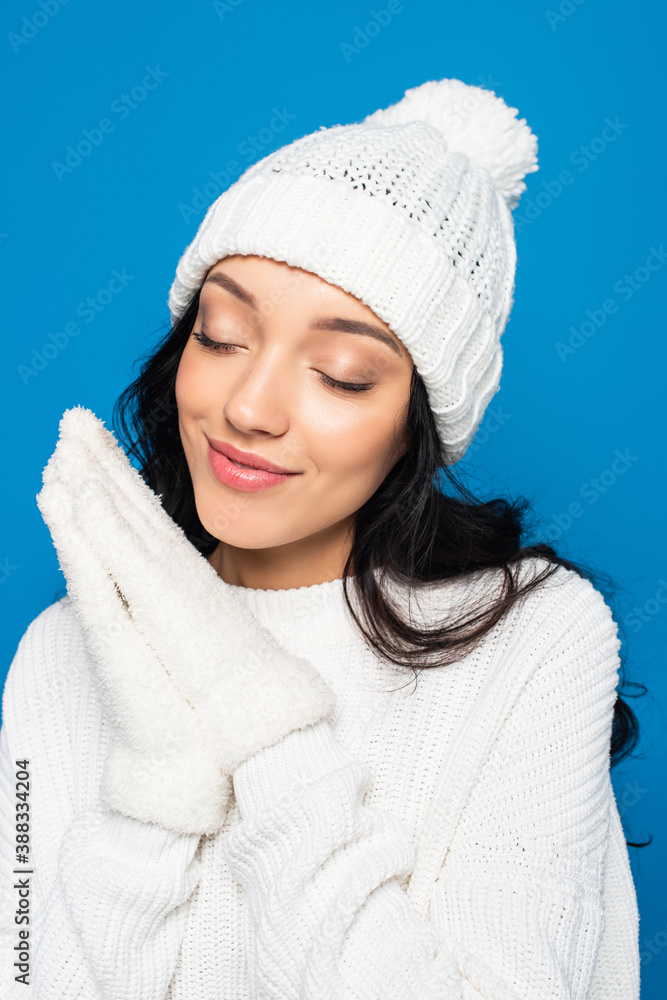 happy woman in knitted hat and gloves isolated on blue happy woman in knitted hat and gloves isolated on blue